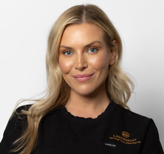 A woman with long blonde hair and blue eyes, wearing a black top with an orange Laser Sight logo, smiles at the camera against a plain white background.